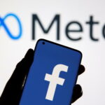 A smartphone with Facebook's logo is seen in front of displayed Facebook's new rebrand logo Meta in this illustration